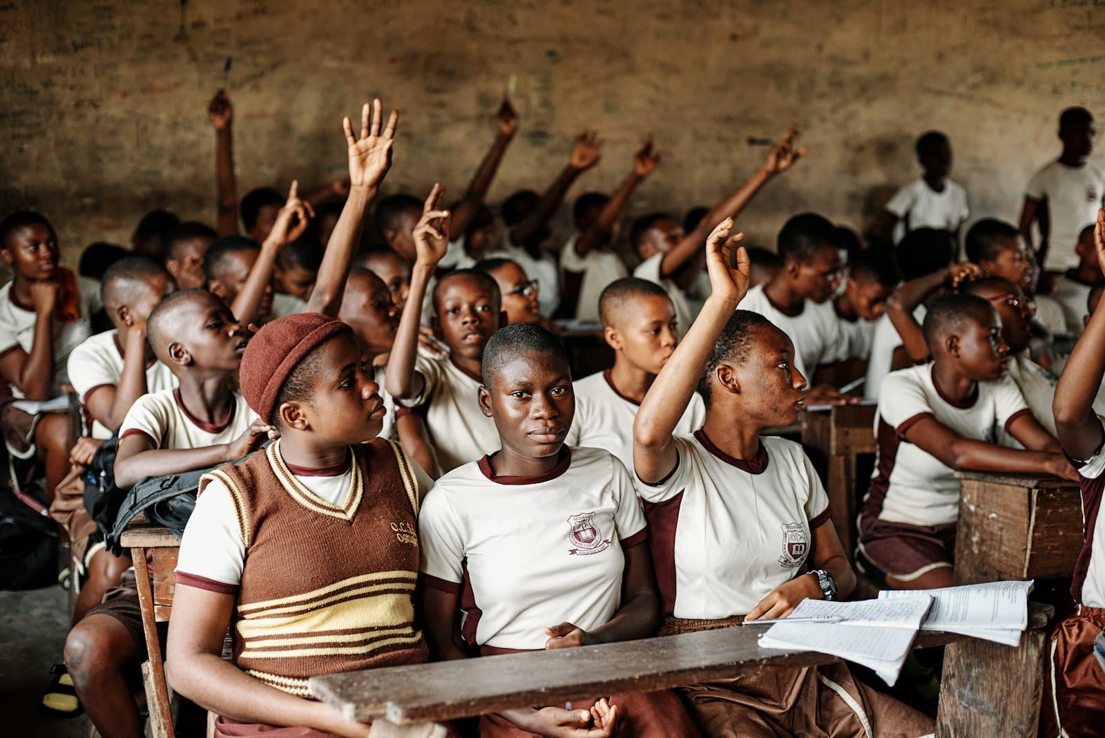 Pupils raising their hands in a classroom