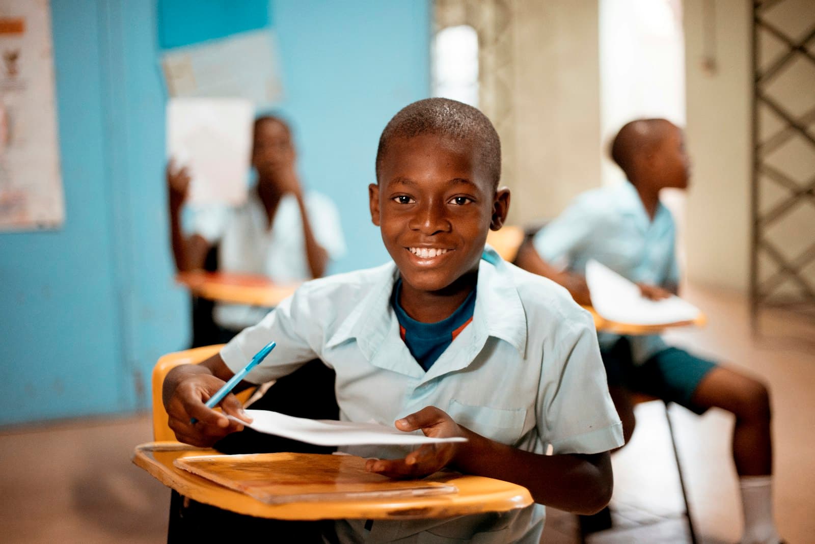 A smiling pupil holding their work